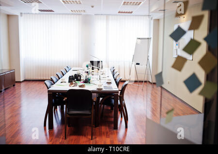 Moderne Business Office Interior mit Tischen und Stühlen, Laptop, Kamera und Bürobedarf ohne Beschäftigte. Stockfoto