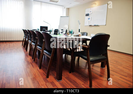 Moderne Business Office Interior mit Tischen und Stühlen, Laptop, Kamera und Bürobedarf ohne Beschäftigte. Stockfoto