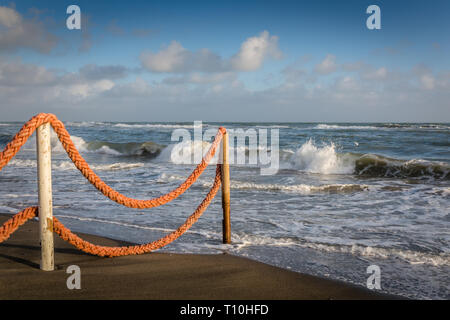 Am späten Nachmittag Strand, Meer mit Seil Zaun mit Blick aufs Meer mit Wellen zu Stockfoto