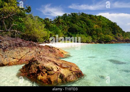 Vulkangestein im türkisblauen Meer und tropischen Strand auf Koh Chang Insel, Thailand. Stockfoto