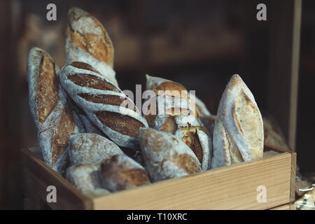 Brot Brote, Große und Kleine, in einer Holzkiste auf dem Zähler in einer Bäckerei, frischem Gebäck und Mehl Produkte Stockfoto