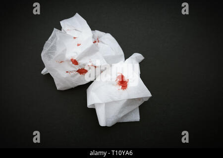 Weisse Serviette mit Blut auf einem dunklen Hintergrund. Stockfoto