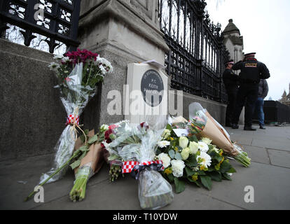 Blumen rund um das Denkmal PC Keith Palmer, der während der Westminster Terroranschlag getötet wurde, außerhalb der Palast von Westminster, London zu Ehren platziert, auf das 2-jährige Jubiläum des Angriffs. Stockfoto