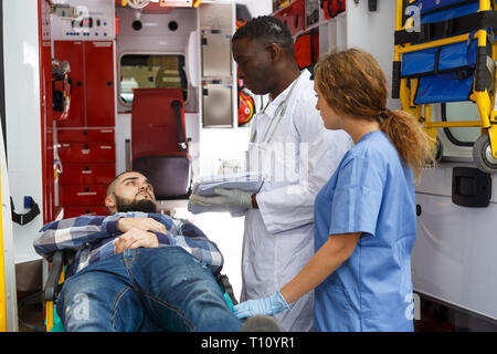 Sanitäter geben Patienten Logbuch für Signatur im Krankenwagen autom. Stockfoto