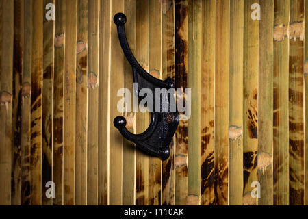 In der Nähe der eisernen Haken für Kleidung auf einem Holz- Hintergrund. Stockfoto