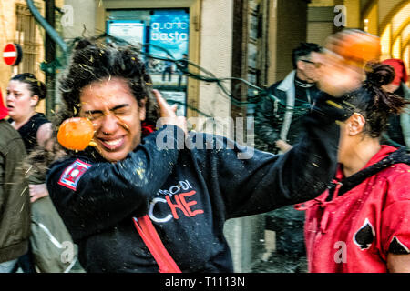 Highlights der Schlacht der Orange, in Ivrea bei Turin, Italien, wo die orange Werfer auf dem Boden Angriff der orange Werfer, die sich auf der Karre defende, mit Anschlägen von Orange Stockfoto