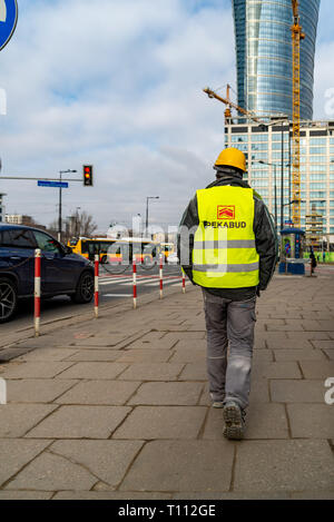 Die Builder geht an Bau entlang der Straße. Builder in der Nähe der Ampel. Der Bau eines neuen Wolkenkratzers. Ansicht des Gebäudes aus der r Stockfoto
