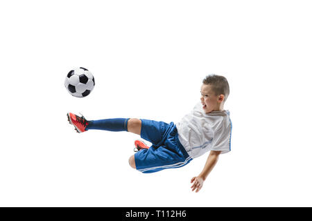 Junge kickt den Ball. Foto auf weißem Hintergrund. Fußball-Spieler in Bewegung im Studio. Fit springen Junge in Action, Jump, Bewegung im Spiel. Stockfoto