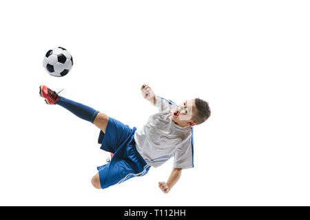 Junge kickt den Ball. Foto auf weißem Hintergrund. Fußball-Spieler in Bewegung im Studio. Fit springen Junge in Action, Jump, Bewegung im Spiel. Stockfoto