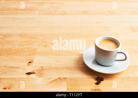 Tasse Kaffee oder Espresso und Kaffee Bohnen auf Holztisch. Kopieren Sie Platz für Text. Stockfoto