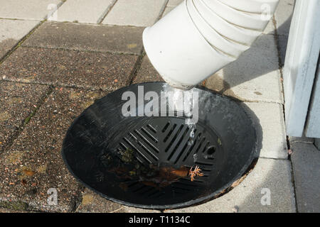 Wasser fließt aus Metall Dachrinne. Stockfoto