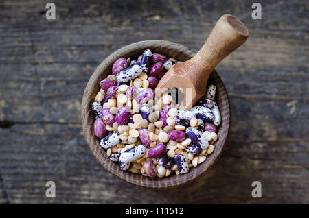 Sortiment von trockenen organischen Bohnen und Linsen in der Schüssel auf rustikalen Holztisch. Vielzahl an raw Hülsenfrüchte. Ausgewogene Ernährung, Kochen, vegetarische und sauber eatin Stockfoto