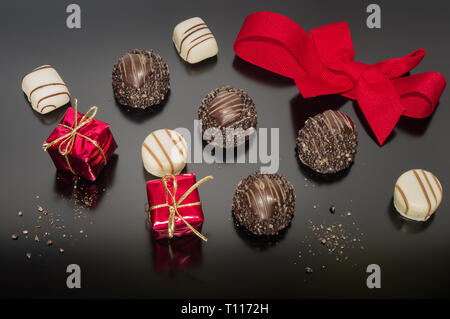 Sortiment süßes Süsswaren Schokolade. Bonbons und Pralinen für Weihnachten Tabelle mit roter Schleife gebunden. Quadrat, Geschenk, Dekor. Stockfoto