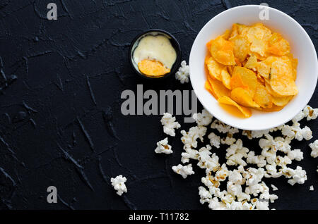 Fast Food und ungesundes Essen Konzept. Nahaufnahme von Fastfood Snacks: Popcorn und Chips mit Soße. Auswahl der Kohlenhydrate Produkte schlecht für Stockfoto