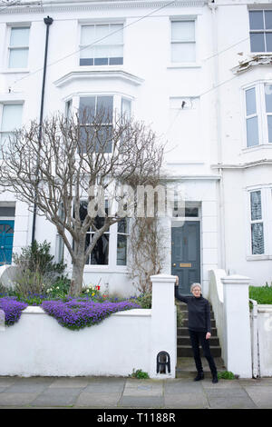 Eine weibliche Brighton home Eigentümer steht vor ihrem georgischen Reihenhaus. Stockfoto