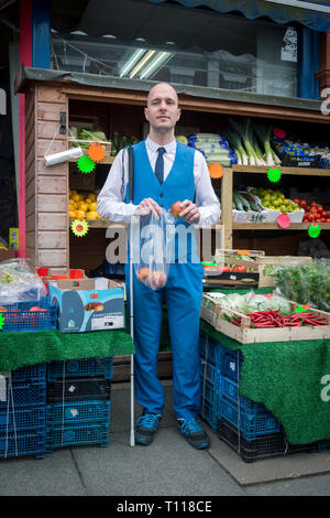 Ein Blinder mit dem Stock, kauft seine Lebensmittel in einem Obst und Gemüse Lebensmittel Shop Stockfoto