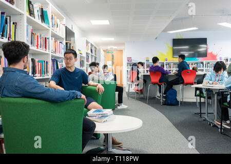 Die Schüler sitzen und arbeiten in der Schule/Hochschule Bibliothek zu überarbeiten Stockfoto