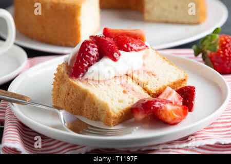 Teil der Engel essen Kuchen mit Sahne und Erdbeeren serviert. Stockfoto