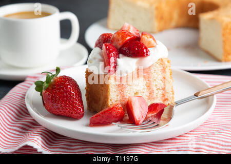 Teil der Engel essen Kuchen mit Sahne und Erdbeeren serviert. Stockfoto