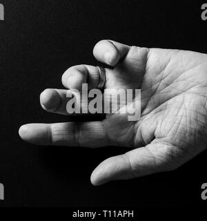 Schwarz/Weiß-Bild von der Hand des Menschen, öffnen Sie Palm nach oben zeigt, auf einem schwarzen Hintergrund mit dramatischen Begrenzungslicht isoliert. Stockfoto