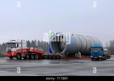 Mariehamn, Finnland - 16. März 2019: Scania 144 G tank Lkw klein im Vergleich zu Sisu Hauler und grossen Silo außergewöhnliche Belastung von 45 Metern und 156 Tonnen. Stockfoto