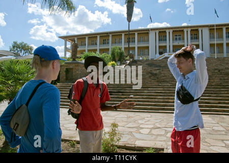 Ein Reiseleiter spricht zu europäischen Besucher außerhalb der Tintenpalast (Tinte Palast), dem Sitz der Namibischen Gesetzgebung in Windhoek, Namibia. Stockfoto