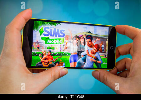 Berdyansk, Ukraine - März 4, 2019 - Nahaufnahme von Hand der Person spielen Die Sims Mobile Game Anmeldung Stockfoto