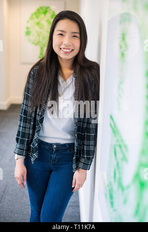 Eine junge Südostasiatische Frau steht im Flur eines Cambridge College. Stockfoto