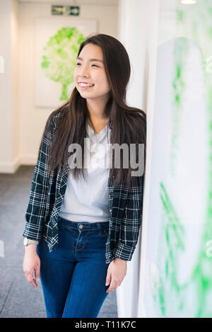 Eine junge Südostasiatische Frau steht im Flur eines Cambridge College. Stockfoto