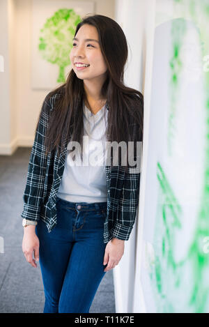 Eine junge Südostasiatische Frau steht im Flur eines Cambridge College. Stockfoto