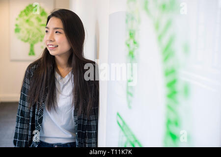 Eine junge Südostasiatische Frau steht im Flur eines Cambridge College. Stockfoto