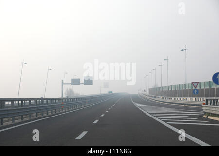 Dichter Nebel sehr gefährlich für die Autofahrer auf der Autobahn Abfahrt im Winter Stockfoto