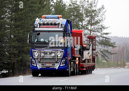 Salo, Finnland - 15. März 2019: Volvo FH 16 750 Auflieger von Lavettikuljetus Ylitalo & Vahtera Oy hols Sandvik LH 209 L U-Lader auf die Straße. Stockfoto