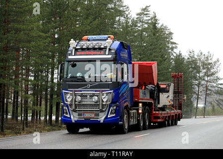 Salo, Finnland - 15. März 2019: Volvo FH 16 750 Auflieger von Lavettikuljetus Ylitalo & Vahtera Oy hols Sandvik LH 209 L U-Lader auf die Straße. Stockfoto