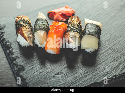 Sushi am Schwarzen Stein board Ein, Holz- Hintergrund Stockfoto