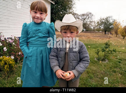 Eine junge Schwester und Bruder darstellen, draußen auf dem Hof der Familie in einer mennonitischen Gemeinde im Bundesstaat Chihuahua im Nordwesten von Mexiko. Die Mennoniten in Chihuahua sind Nachfahren des 16. Jahrhunderts Schweizer Wiedertäufer, die nach Kanada in den späten 1800 verschoben s Verfolgung für ihren Glauben zu vermeiden. In den 1920er Jahren, die Mennoniten nach Süden nach Mexiko, wo so viel wie 100.000 leben heute in verschiedenen Teilen des Landes. Stockfoto