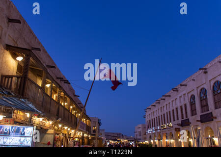 Souq Waqif nachts mit einer Flagge Katar in Doha, Katar im Nahen Osten. Stockfoto