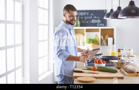 Lächelnd und selbstbewusst Koch stehen in großen Küche Stockfoto