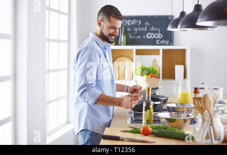 Lächelnd und selbstbewusst Koch stehen in großen Küche Stockfoto