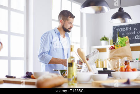 Lächelnd und selbstbewusst Koch stehen in großen Küche Stockfoto