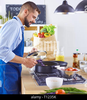 Lächelnd und selbstbewusst Koch stehen in großen Küche Stockfoto