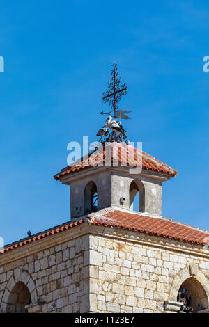 Paar Störche ein Nest auf dem Kirchturm der Kirche. Sonnigen Tag und blauer Himmel. Stockfoto