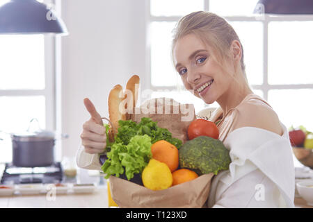 Junge Frau mit Einkaufen Tasche mit Gemüse Standi Stockfoto