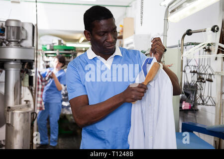 Erfahrene Afrikaner - Mann bei der Arbeit in der modernen Reinigung Stockfoto