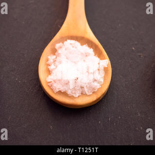 Löffel aus Holz mit Salz Blume Flocken auf einer Schiefertafel Platte Stockfoto