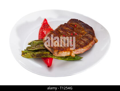 Lecker gebratenes Rindfleisch Lende serviert mit Gemüsegarnitur der gedünstete grüne Bohnen und rote Paprika. Auf weissem Hintergrund Stockfoto