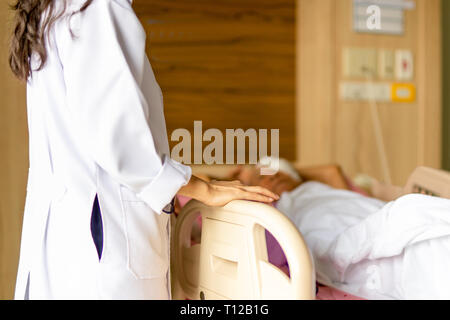 Arzt im Gespräch mit Patienten, während der Patient im Bett im Krankenhaus. Stockfoto