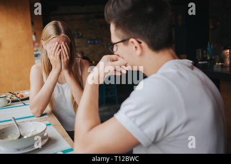 Streit zwischen zwei jungen Menschen in einem Kaffeehaus, in einer Bar oder Restaurant. Stockfoto