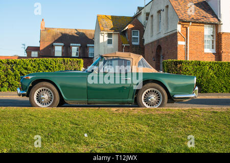 Klassische Triumph TR4 Cabrio Sportwagen in Racing Green in der Nähe der Klippen von Hunstanton, Norfolk, Großbritannien geparkt. Stockfoto