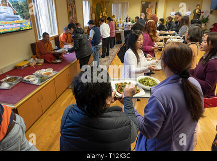 Anbeter in einem buddhistischen Tempel Form einer Montagelinie zu dienen Essen, besonders für ihre Mönche vorbereitet. In Elmhurst, Queens, New York City. Stockfoto